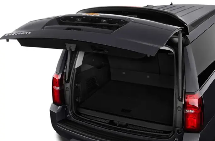 A trunk of a black car with the door open.