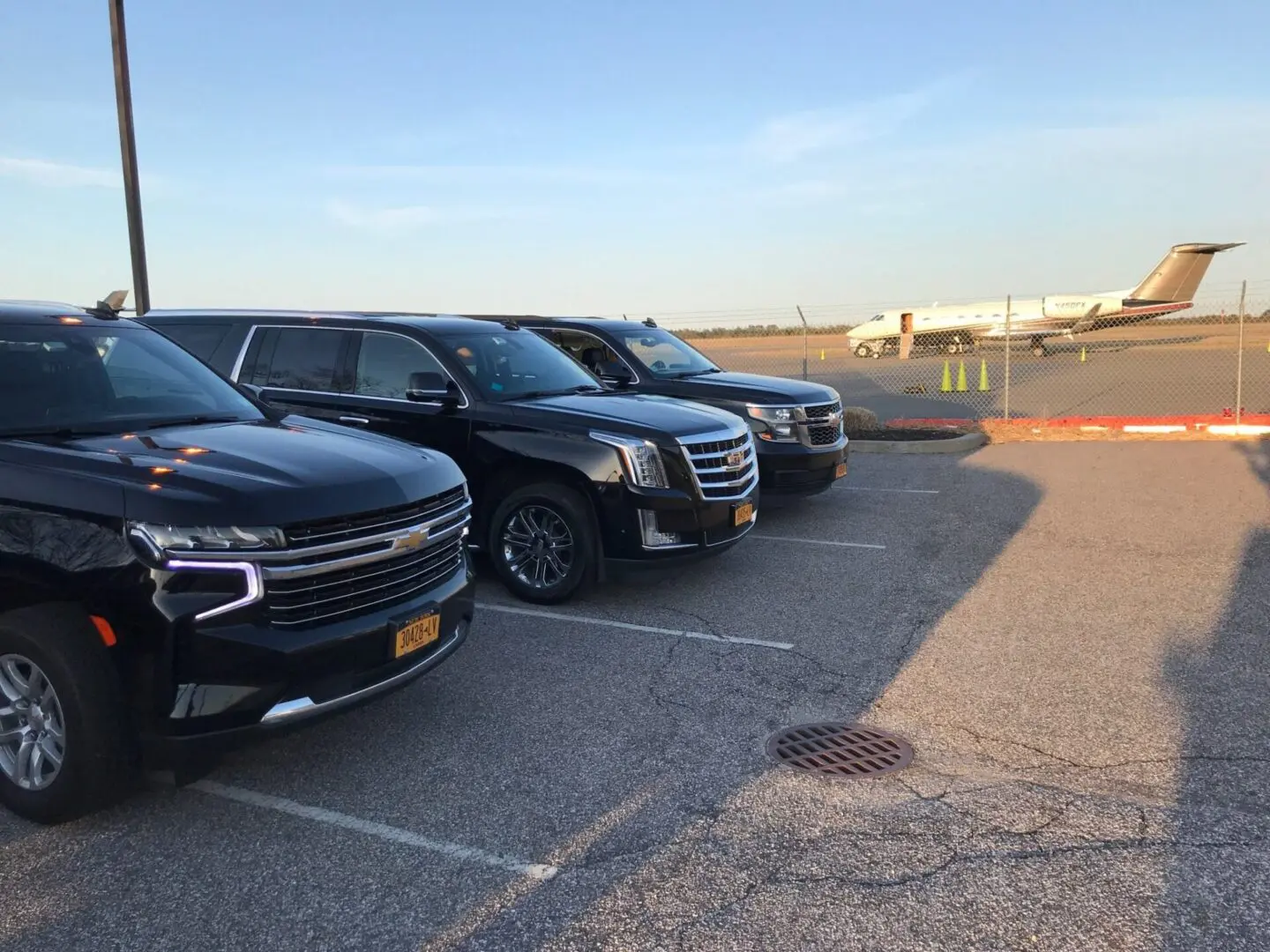A row of black cars parked in a parking lot.