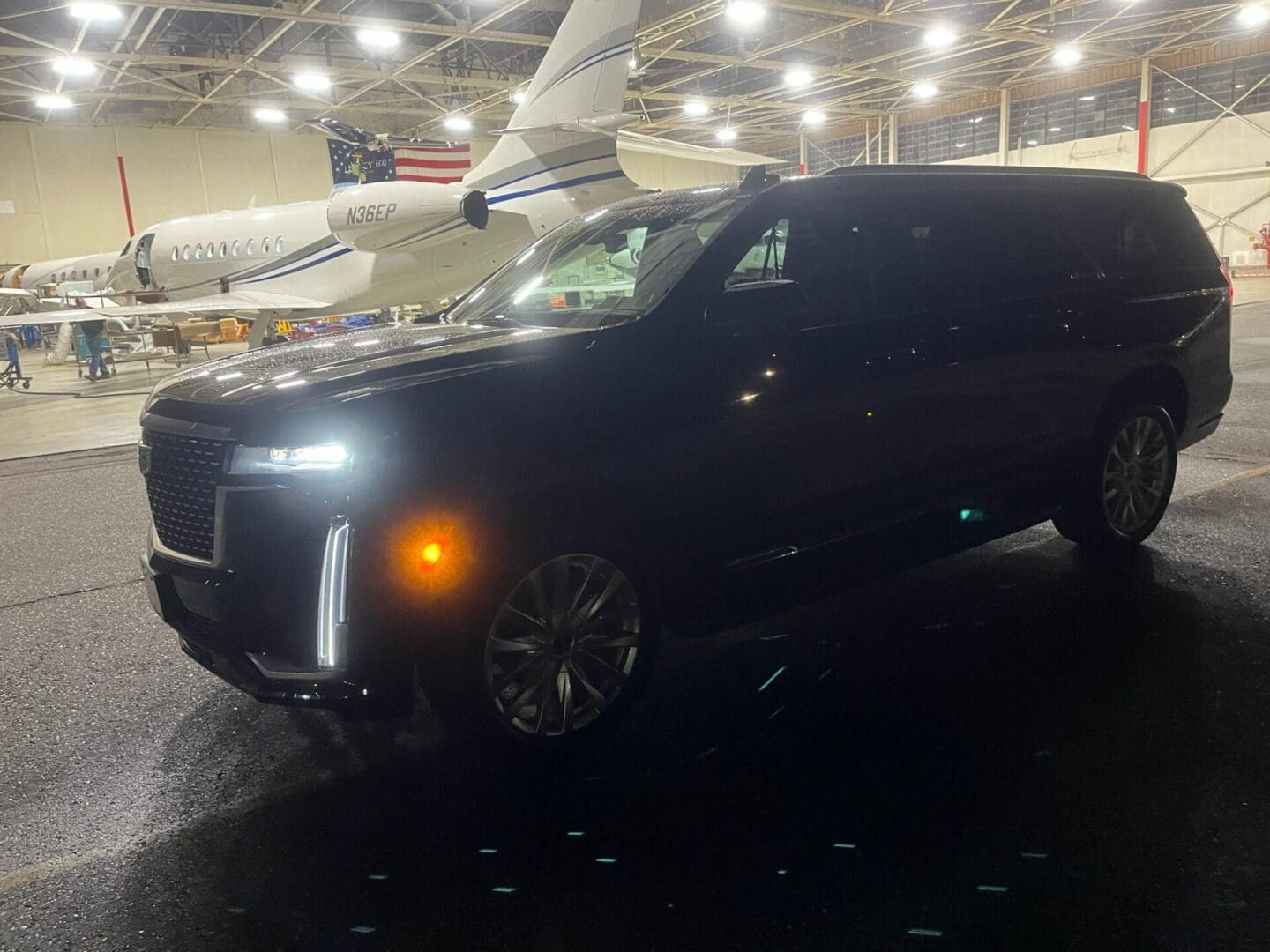 A black suv parked in an airport hangar.